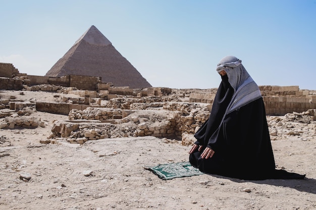 La donna musulmana con l'abito veste salat nel deserto