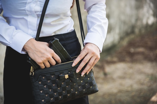 La donna nasconde portare l'arma mano che tiene rimuovendo la piccola pistola dalla sua borsa