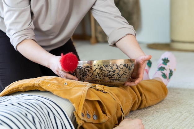 La donna ottiene il massaggio con campane tibetane e la terapia del suono dalla pratica medica tradizionale del Nepal