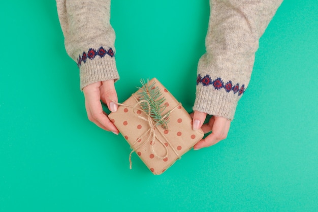 La donna passa il contenitore di regalo della tenuta su verde