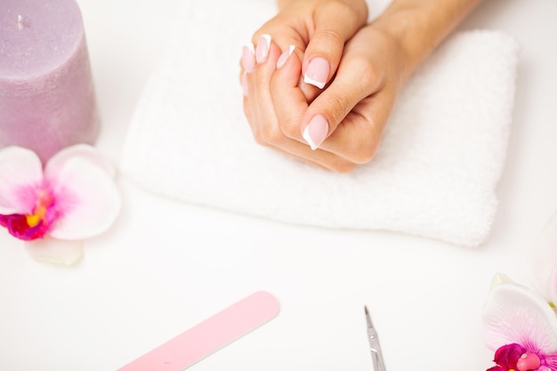 La donna per la cura delle unghie mostra una manicure fresca fatta in uno studio di bellezza
