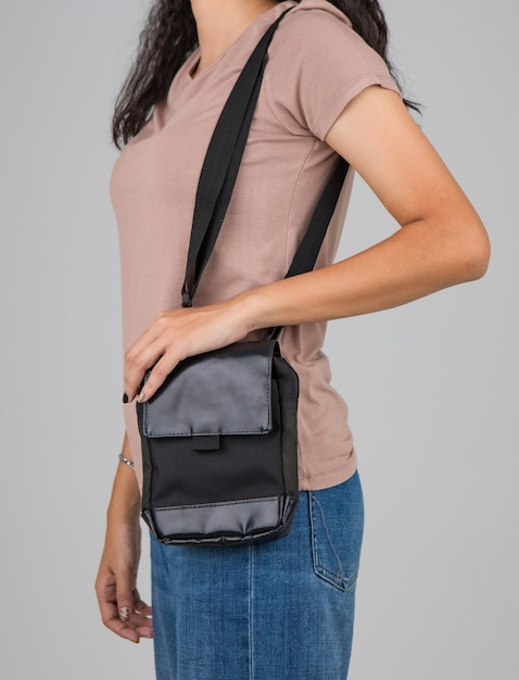 La donna porta la borsa casual sulla spalla con un gesto attivo e facile.