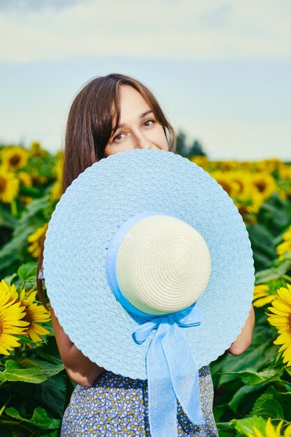 La donna positiva si nasconde con il cappello blu a tesa larga