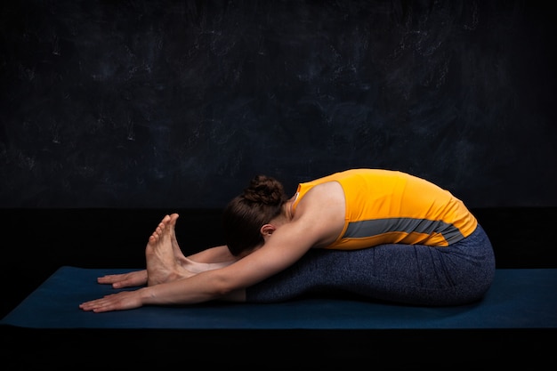 La donna pratica Ashtanga Vinyasa yoga asana Paschimottanasana