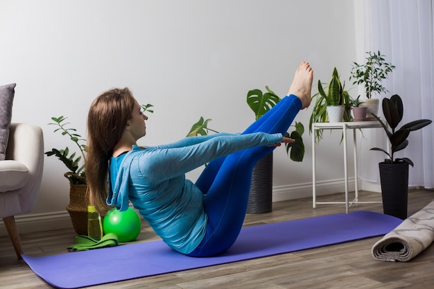 La donna pratica yoga a casa durante la quarantena