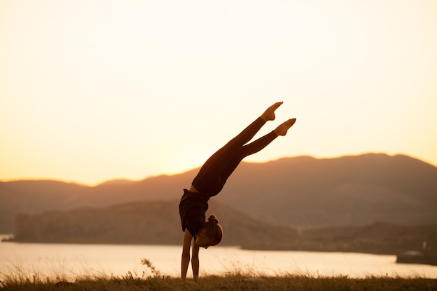 la donna pratica yoga in montagna sull'oceano.