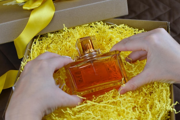 La donna prende il profumo fragrante da una confezione regalo. bel regalo per una donna