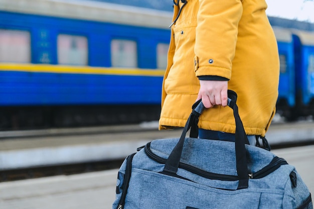 La donna prende la borsa alla stazione ferroviaria. concetto di viaggio