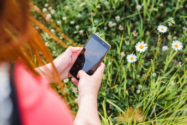 La donna prende la foto dei fiori sul cellulare