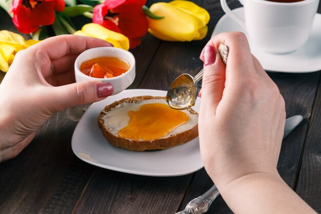 La donna prende la marmellata sul pane