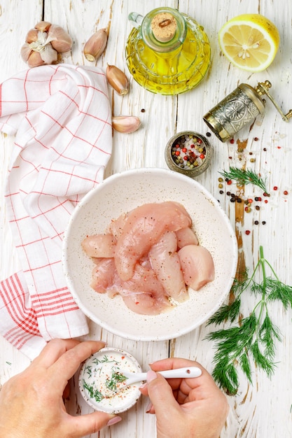 La donna prepara filetto di pollo in salsa di yogurt greco al limone,