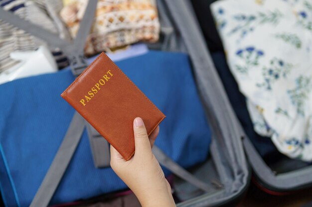 La donna prepara il bagaglio e il passaporto nella valigia pronta a viaggiare per un nuovo viaggio preparando una vacanza con i bagagli