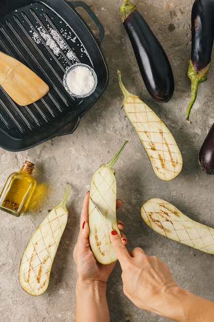 La donna prepara melanzane con ripieno vegano e pinoli