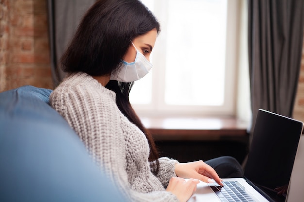 La donna resta a casa durante un'epidemia e lavora su un computer portatile