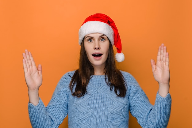 La donna scioccata con il cappello mostra qualcosa di grande e di grandi dimensioni