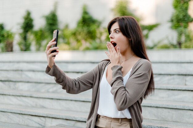 La donna scossa esamina il telefono