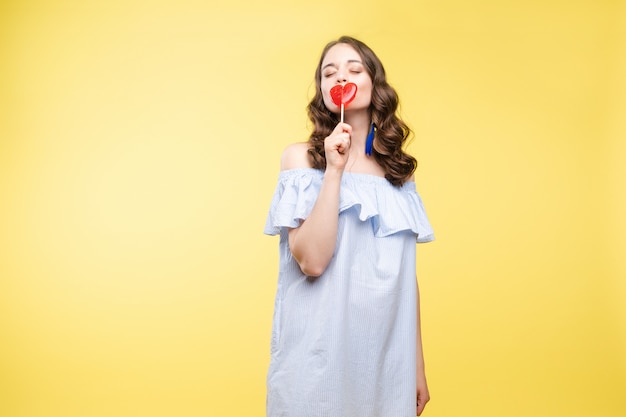 La donna seducente gradisce la bambola dolce con la caramella.