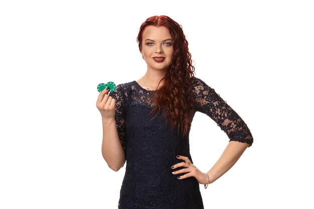 La donna sexy dai capelli rossi con i capelli ricci è in posa con alcune blue chips nelle sue mani. Poker