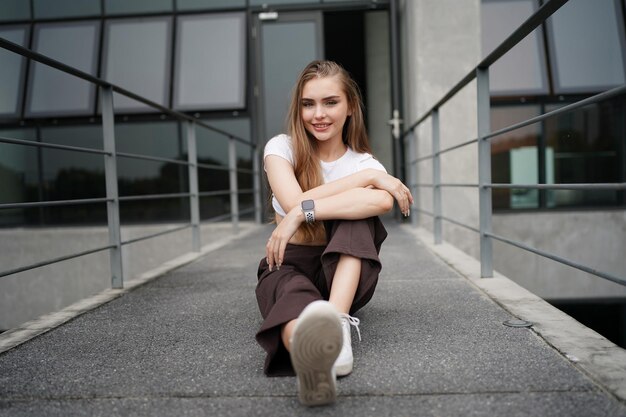 La donna si diverte a posare in un posto bianco minimo. Posto e sfondo bianchi minimi e bella signora bionda caucasica nell'interno del caffè minimo.