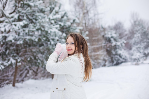 La donna si diverte mentre gioca a palle di neve in inverno