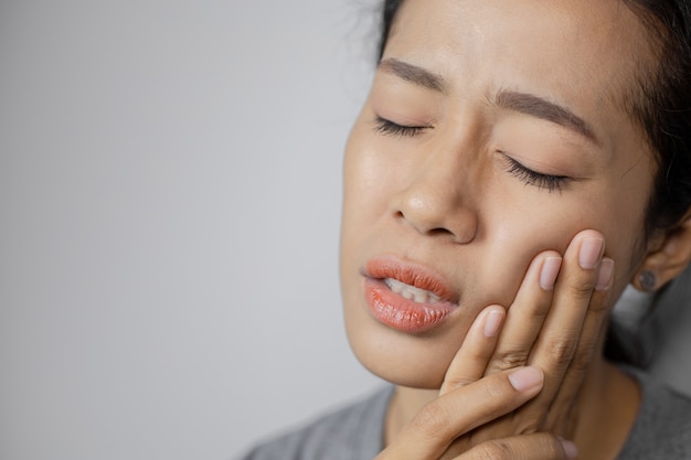 La donna si è messa la mano sulla guancia a causa del mal di denti.