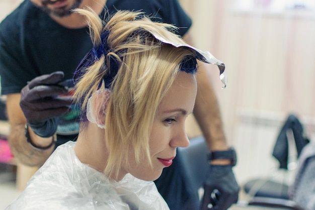 La donna si è tinta i capelli di blu dal parrucchiere Taglio di capelli creativo e cambia l'immagine di una donna Parrucchiere stilista che fa il suo lavoro nel salone