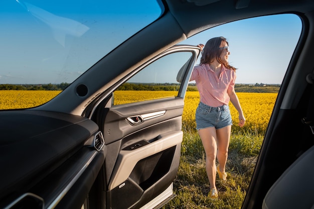 La donna si ferma per godersi il tramonto durante il viaggio in auto