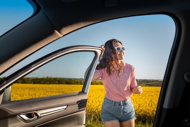 La donna si ferma per godersi il tramonto durante il viaggio in auto