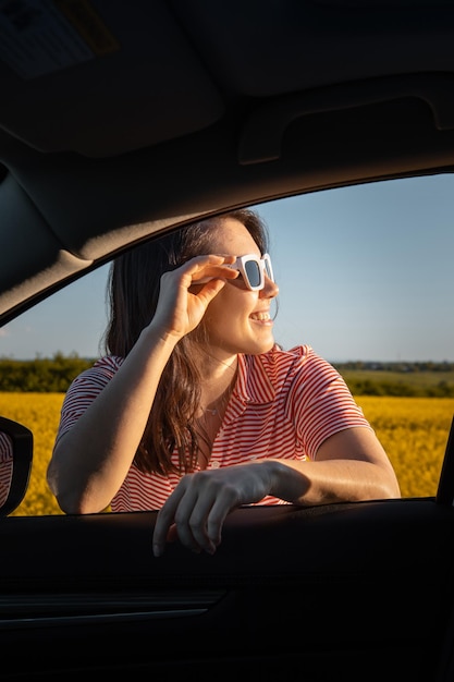 La donna si ferma per godersi il tramonto durante il viaggio in auto