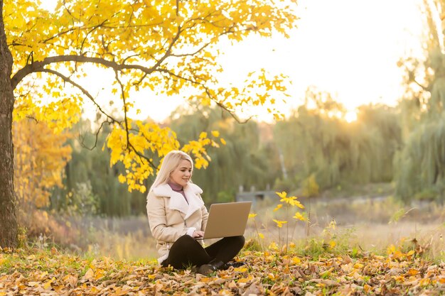 la donna si rilassa nel parco mentre lavora al suo laptop