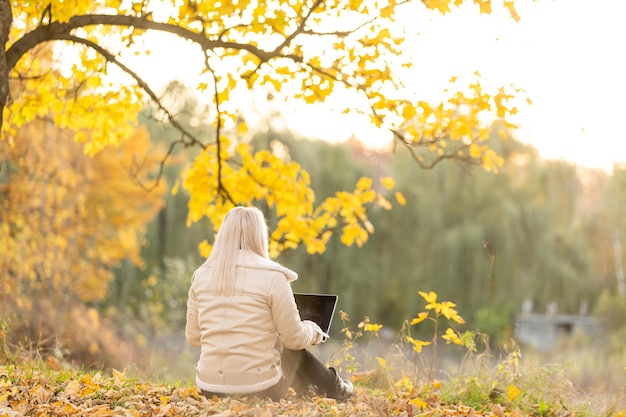 la donna si rilassa nel parco mentre lavora al suo laptop