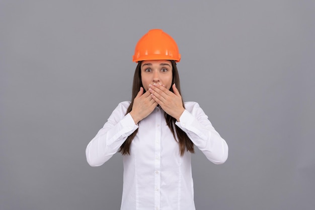 La donna sorpresa con il casco protettivo e la camicia bianca chiude lo stupore del viso stupito