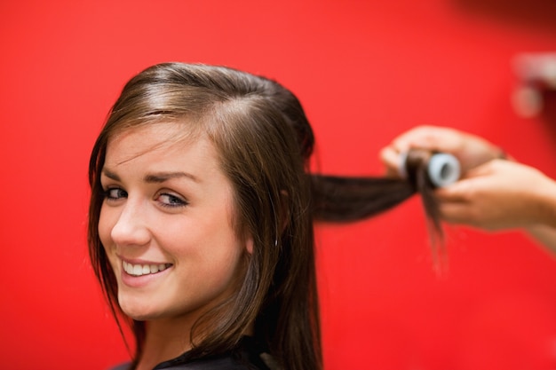 La donna sorridente che ha suoi capelli rotolati