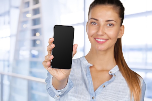 La donna sorridente sta indicando sullo smartphone