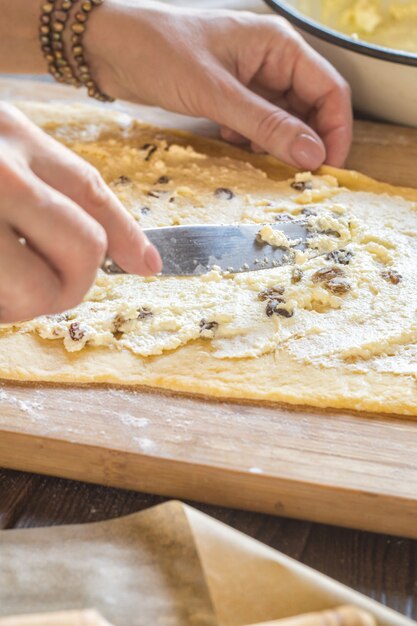 La donna spalma il ripieno di ricotta sull'impasto