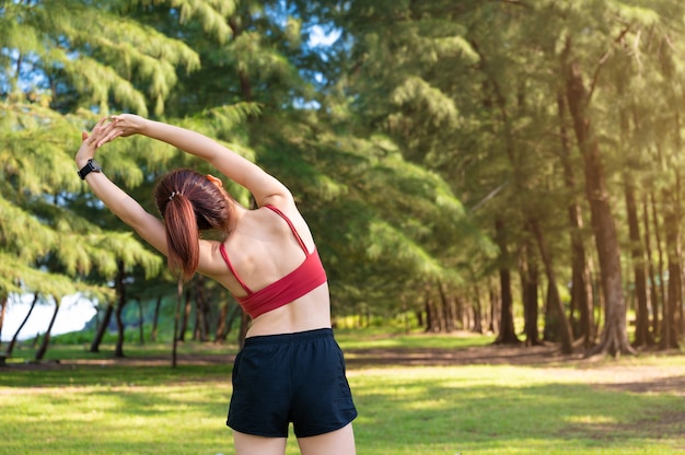 La donna sportiva asiatica risolve e allunga al mattino