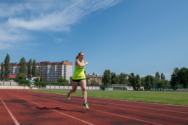 La donna sportiva corre nello stadio