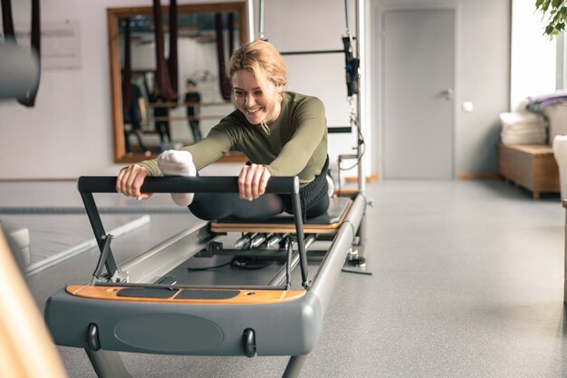 La donna sportiva sta facendo esercizi di stretching in studio moderno