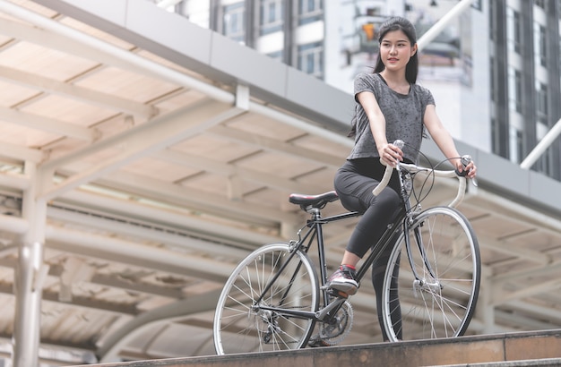 La donna sportiva sta postando con la sua bici sulla scala