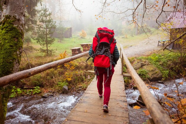 La donna sta attraversando il ponte di legno durante le escursioni