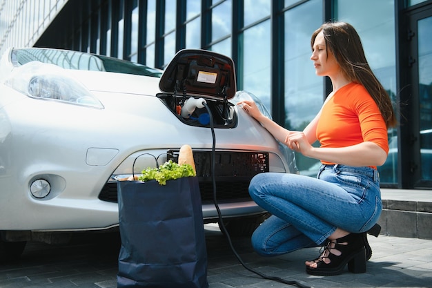 La donna sta caricando un'auto elettrica a noleggio