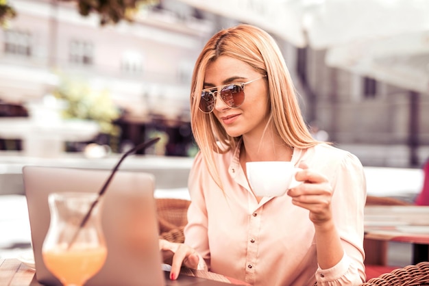 La donna sta controllando la posta in un caffè