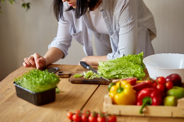 La donna sta cucinando in cucina a casa, utilizzando la tavoletta digitale