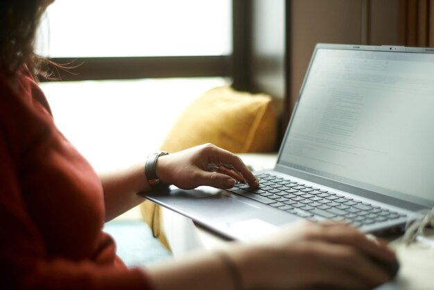 La donna sta digitando l'e-mail sul computer portatile Il libero professionista risponde alle domande dei clienti da casa