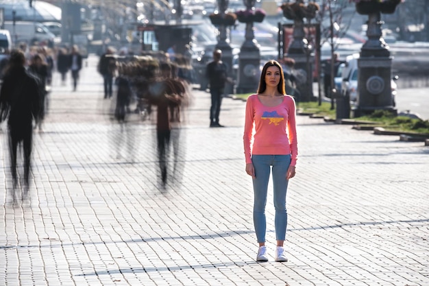 La donna sta in mezzo alla strada affollata