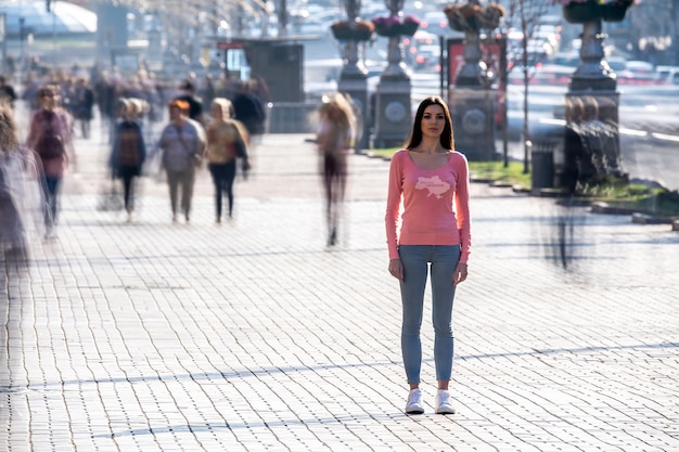 La donna sta in mezzo alla strada affollata