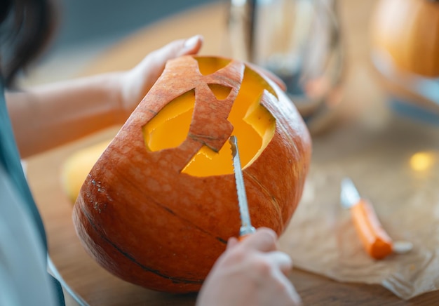 La donna sta intagliando la zucca