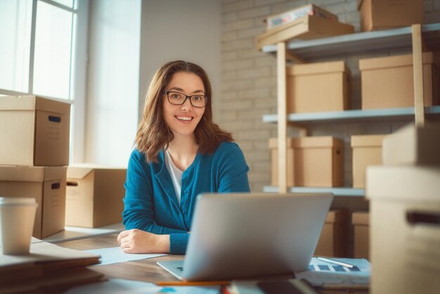 La donna sta lavorando al magazzino per il negozio online.