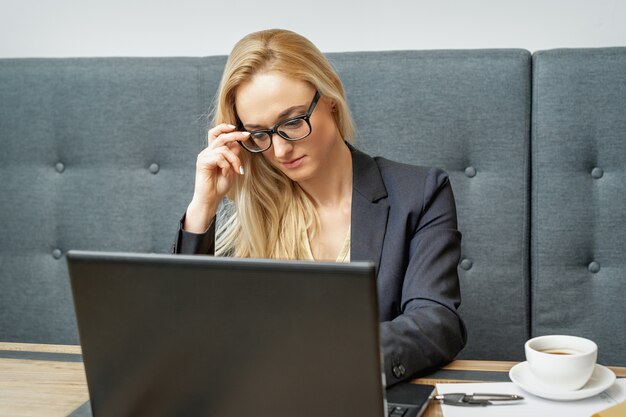 La donna sta lavorando all'ufficio del computer portatile a casa