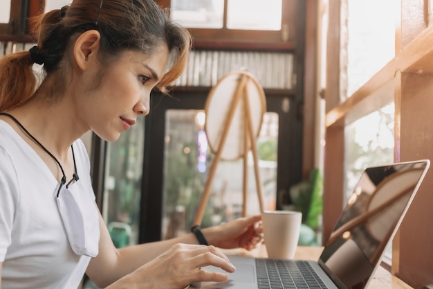 La donna sta lavorando in un caffè con la maschera facciale sul collo